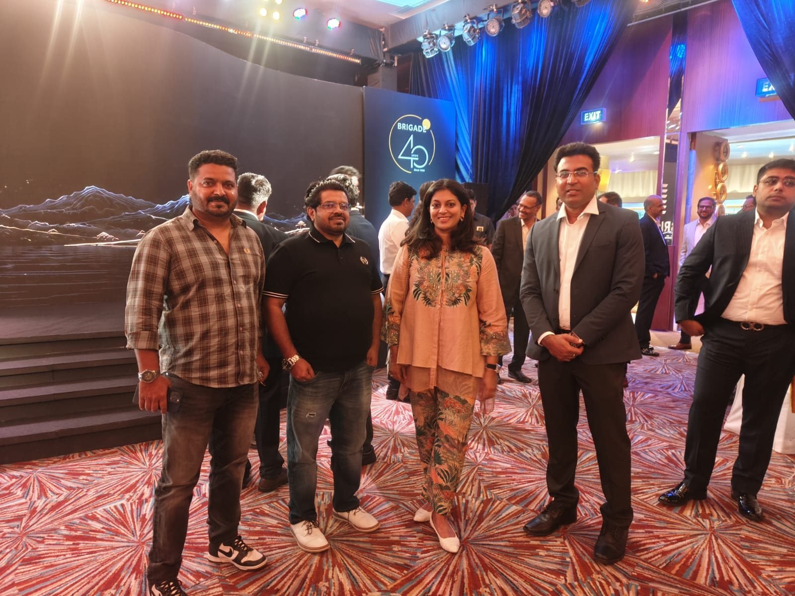 Falcon Properties owners with guests in front of the Brigade 40 Years backdrop at the anniversary celebration